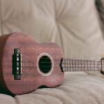 brown ukulele on couch