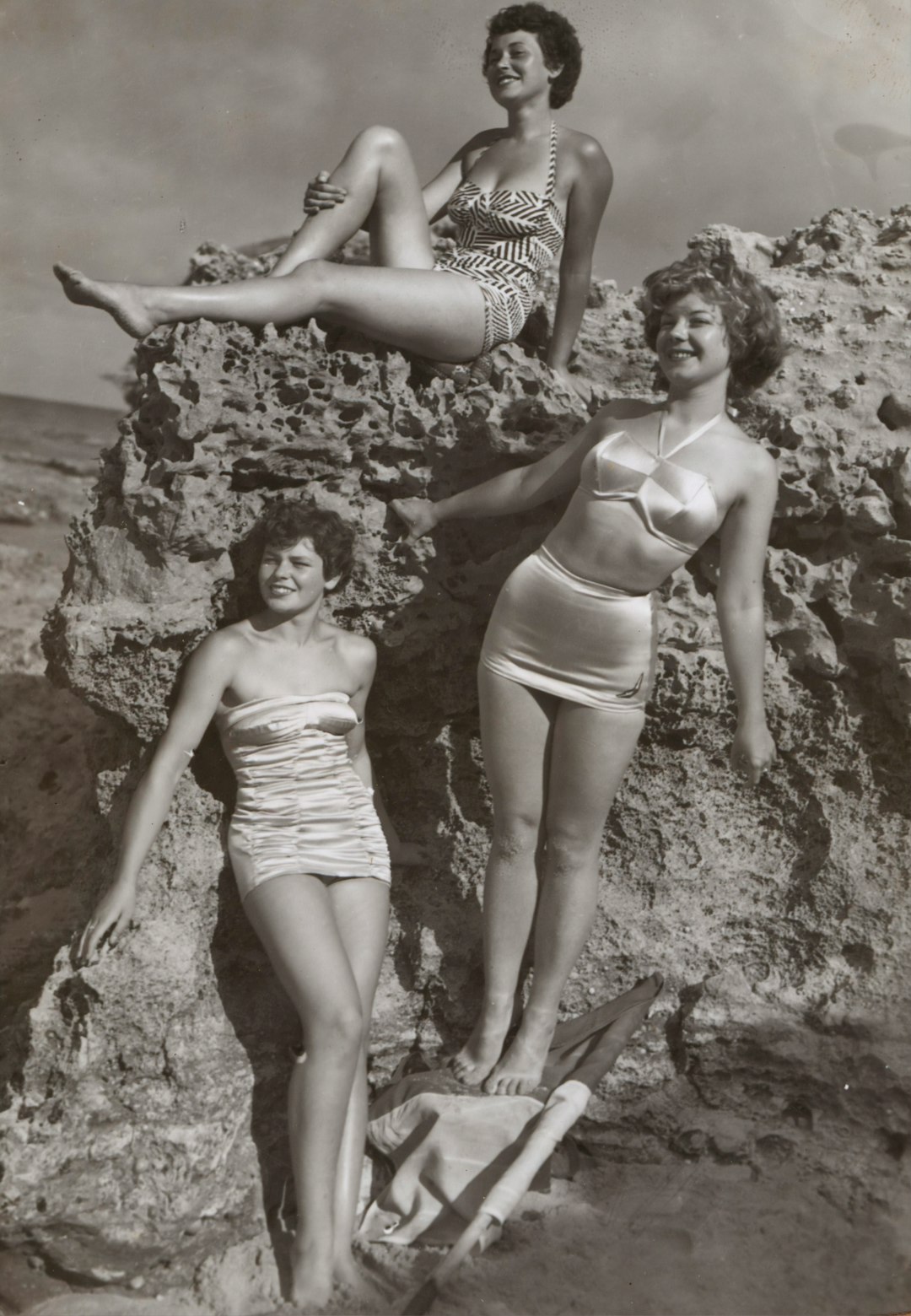 Bernice Kopple, Photograph used in article 'Bonny Scot Beach Girl', Australia,1950s by Guitar Brands grayscale photo of three women standing and sitting on rocks