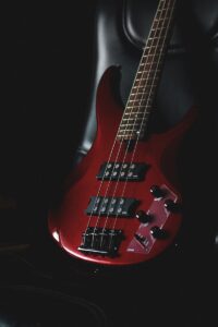 a red Yamaha bass guitar sitting on top of a black chair