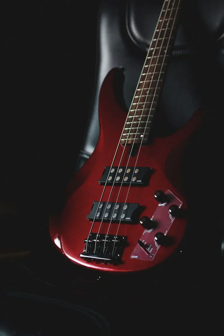 a red Yamaha bass guitar sitting on top of a black chair