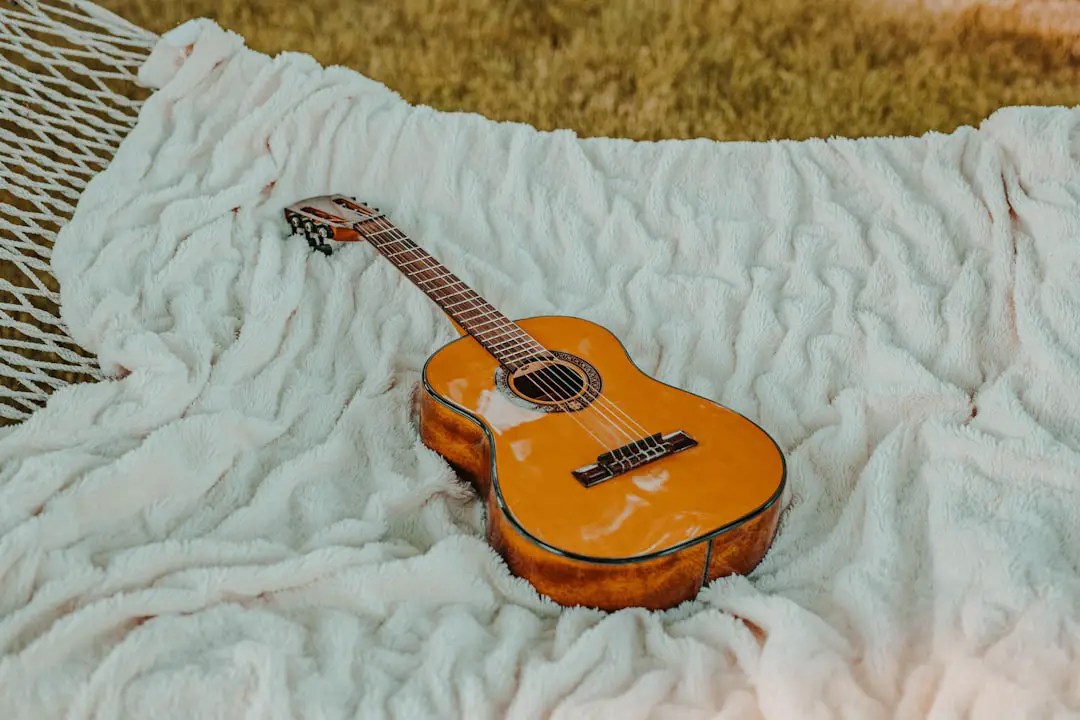 Guitar on hammock by Guitar Brands brown classical guitar on white blanket