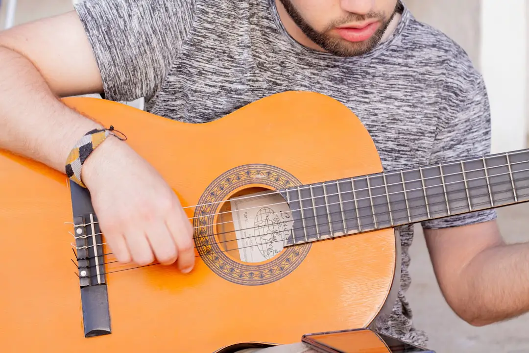 a man holding an orange guitar in his right hand