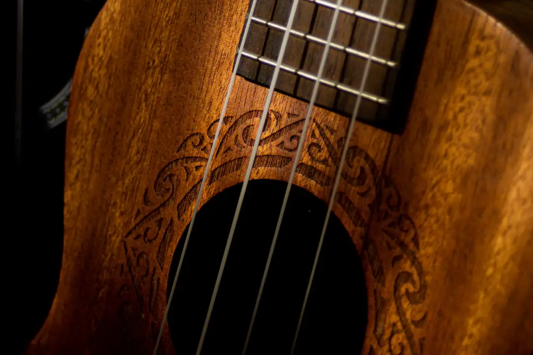 a close up of a wooden guitar with a black background
