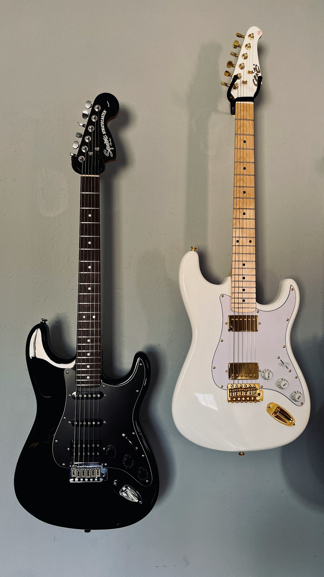 a couple of guitars hanging on a wall
